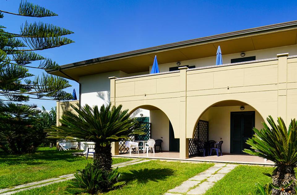 Villetta con archi, giardino e terrazze, immersa nel verde.